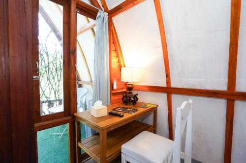 a small room with a table with a lamp on it at Urbanview Onengan Resort in Palang-Putih
