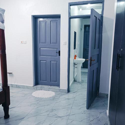 a bathroom with a blue door and a sink at Summer Malindi Family House in Malindi