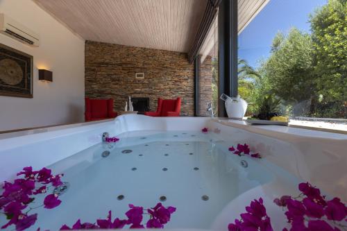 a hot tub in a room with purple flowers at Oliviera Private Island Hotel - Kalem Island in Kalem Adasi