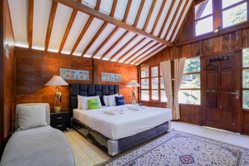 a bedroom with a large bed in a room with wooden walls at Urbanview Onengan Resort in Palang-Putih