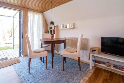 a dining room with a table and chairs and a television at Hexenhaus Finn - Nichtraucher Grundstück in Bodstedt