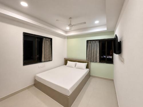 a small bedroom with a bed and a window at Hotel Sunview in Kolkata