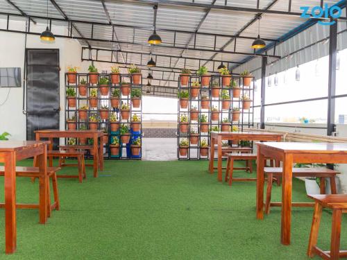 a room with tables and chairs and plants in it at Z Express Leela in Bangalore