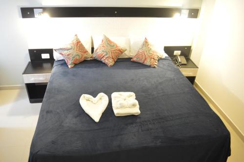 a bed with two towels in the shape of hearts at Hotel Puesta del Sol by Nobile in Encarnación