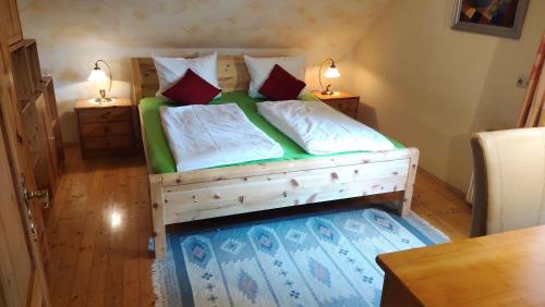 a bedroom with a wooden bed with two pillows at Ferienwohnung Jauk in Gleinstätten
