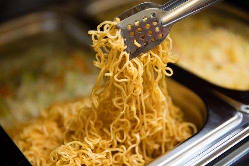 een vork waarmee noedels uit een pan met eten worden gegeten bij Dream Central Hotel & Spa - Hanoi Old Quarter in Hanoi