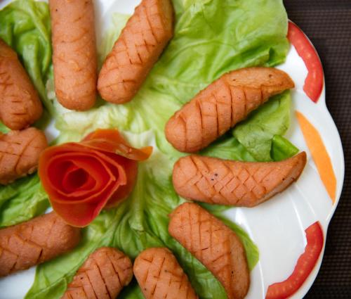 een bord met sla en wortels en een rode roos bij Dream Central Hotel & Spa - Hanoi Old Quarter in Hanoi