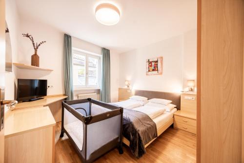 a bedroom with a bed and a television at Pixner Apartments in Bolzano