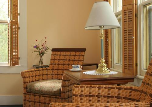 a living room with a table and chairs and a lamp at St. Francis Inn - Saint Augustine in Saint Augustine