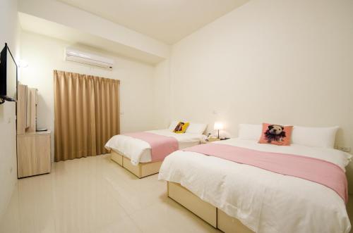 Un dormitorio con dos camas y un televisor. en Successful 168 B&B, en Hualien City