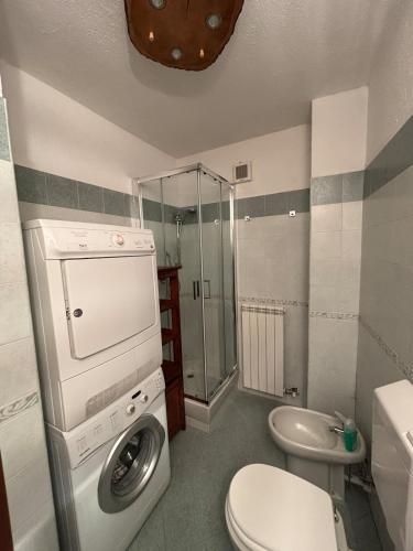 a bathroom with a washing machine and a toilet at Appartamento Grangia Rigat, Bousson, Cesana Torinese in Bousson