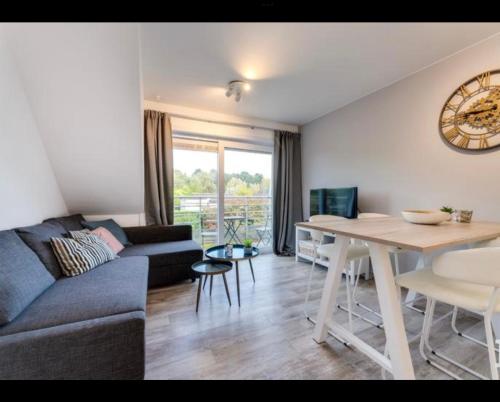 a living room with a couch and a table at Just like home De Haan aan Zee in De Haan