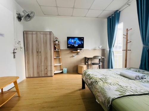 a bedroom with a bed and a table and a television at Căn Studio Áp Mái Full Nội Thất - Gần TTTM Aeon Tân Phú in Ho Chi Minh City