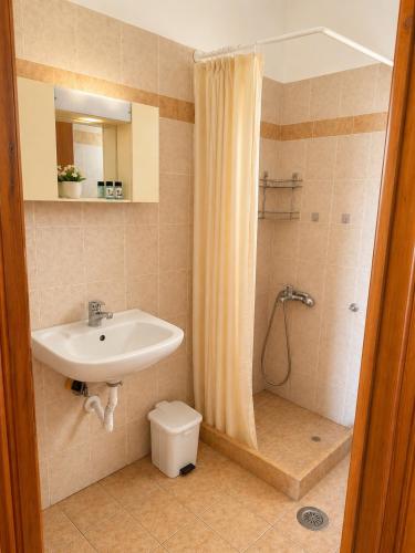 a bathroom with a sink and a toilet and a shower at Τηλεμαχος Apartments in Loutra Edipsou
