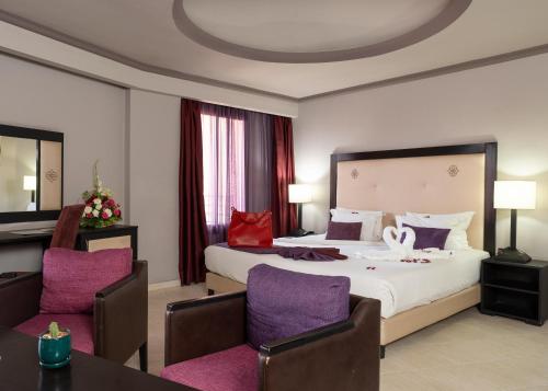a hotel room with a bed with purple chairs at Blue Sea Le Printemps in Marrakesh