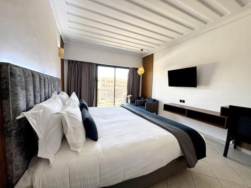 a bedroom with a large bed and a television at Blue Sea Le Printemps in Marrakesh