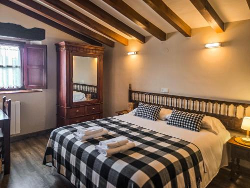 a bedroom with a bed with a black and white checkered blanket at Posada La Solana Santillana del Mar in Santillana del Mar