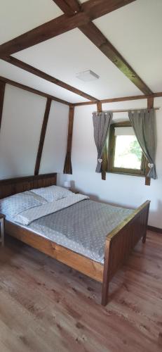 a bedroom with a bed in a room at Zagroda Pod Gontem in Kopalino