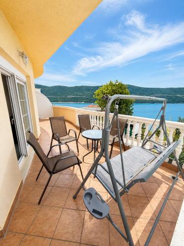 a balcony with chairs and a table and a view of the ocean at Apartmani Villa Amfora - Free Parking in Neum