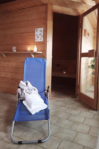 a blue rocking chair with a blanket on a porch at Land-gut-Hotel Seeblick in Klietz
