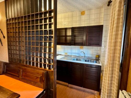 a kitchen with a sink and wooden cabinets at Casa Vacanza Caspoggio in Caspoggio