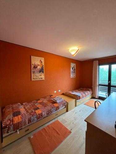 a room with two beds and a table and a kitchen at Casa Vacanza Caspoggio in Caspoggio