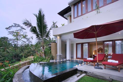 a room with a pool, a chair, and a balcony at Puri Sebali Resort in Ubud