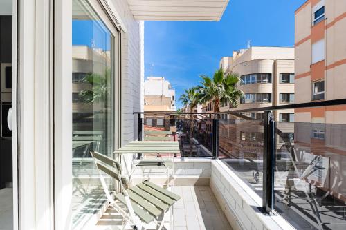 a balcony with chairs and a view of a city at Sunrise Center Suites in Torrevieja