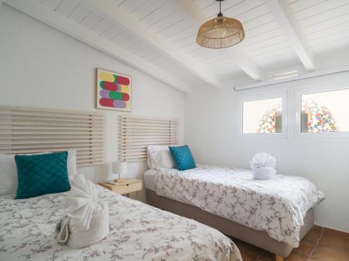 a bedroom with two beds and a ceiling at Oasis Beach Holiday Home with jacuzzi in Playa del Ingles