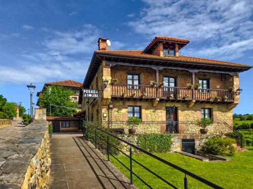 an old stone house with a balcony on a hill at Posada La Solana Santillana del Mar in Santillana del Mar