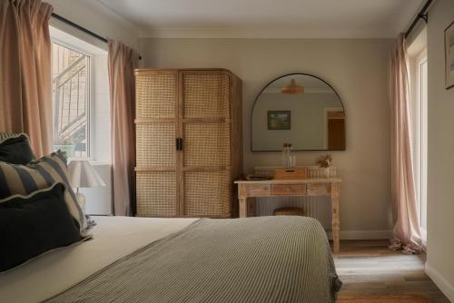 a bedroom with a bed and a mirror and a table at Lulworth Lodge in Lulworth Cove