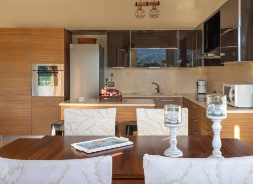 a kitchen with a wooden table with two glasses on it at Family Heritage Homes- Skiathos in Skiathos