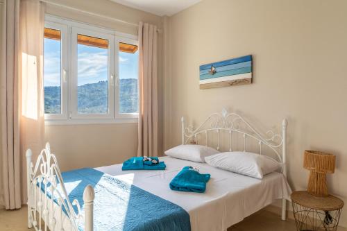 a bedroom with a bed with blue towels on it at Family Heritage Homes- Skiathos in Skiathos