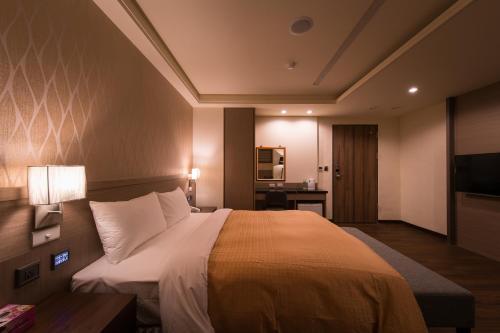 a hotel room with a large bed and a television at Sir Motel - Sanchong in Taipei