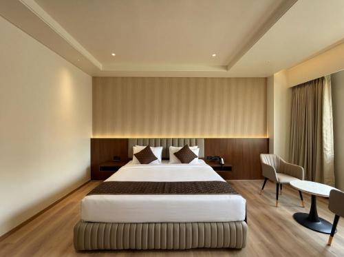 a hotel room with a bed and a desk at The Lynora in Mysore