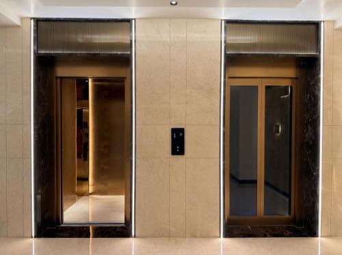 two elevators in a building with their doors open at The Lynora in Mysore