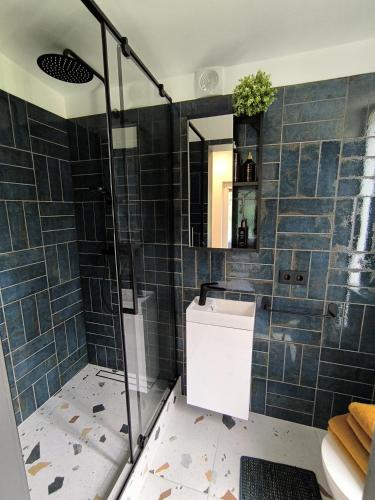 a bathroom with a shower with blue tiles at Riverside weekend cabin in Upesciems