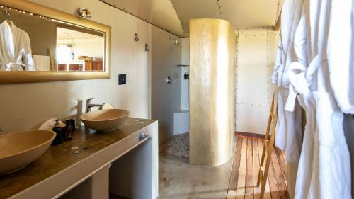 a bathroom with two sinks and a mirror at Windhoek Game Camp in Lafrenz Township