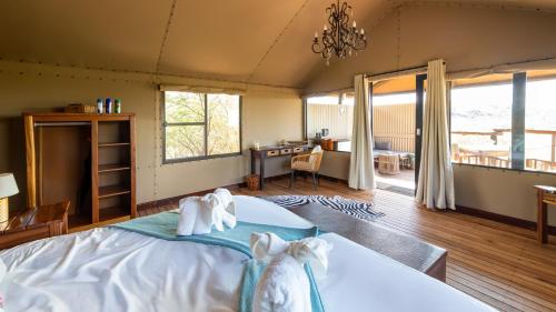 a bedroom with a bed with towels on it at Windhoek Game Camp in Lafrenz Township