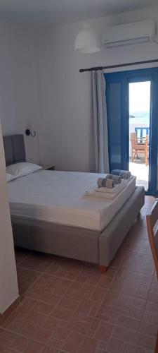 a large bed in a bedroom with a view of the ocean at Keramos in Loutro