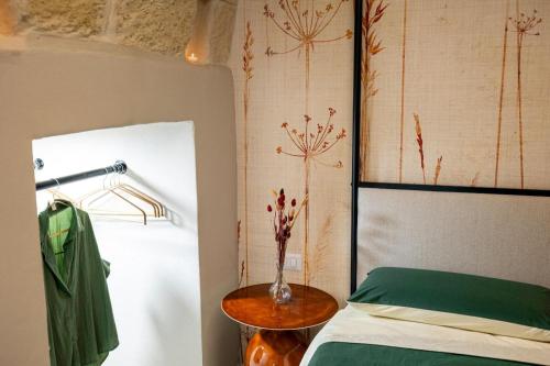 a bedroom with a bed and a vase of flowers on a table at Aria d'amare in Mola di Bari