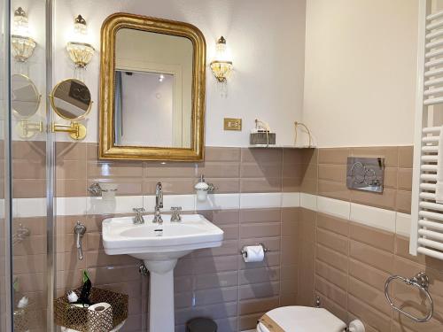 a bathroom with a sink and a mirror and a toilet at Dimora Decò in Lugo