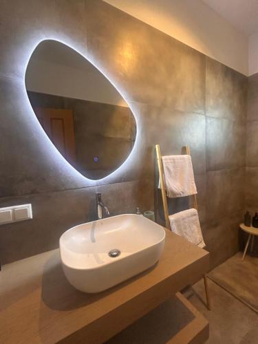 a bathroom with a white sink and a mirror at Grey House in Chorafakia