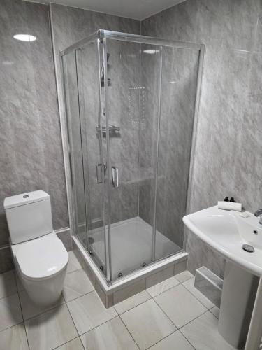 a bathroom with a shower and a toilet and a sink at The Paddington House in Warrington
