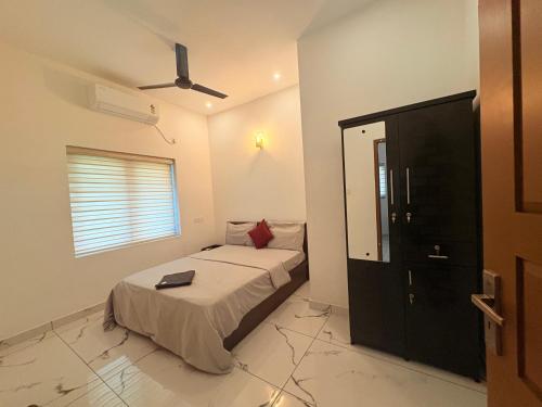 a bedroom with a bed and a ceiling fan at Zensta Residency in Cochin
