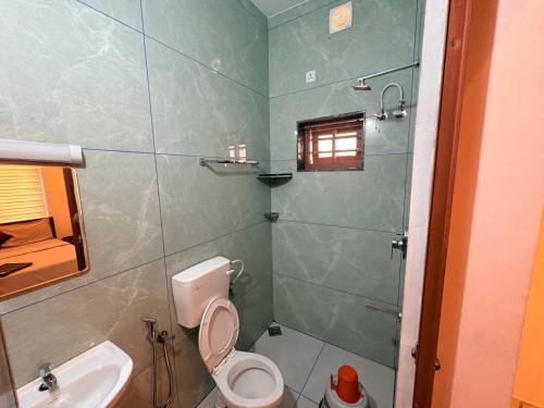a bathroom with a toilet and a sink and a shower at Zensta Residency in Cochin