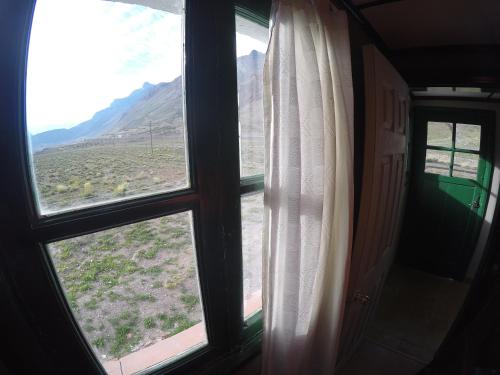 a window with a view of the desert from a train at Hospedaje Leñas del Tolosa in Las Cuevas