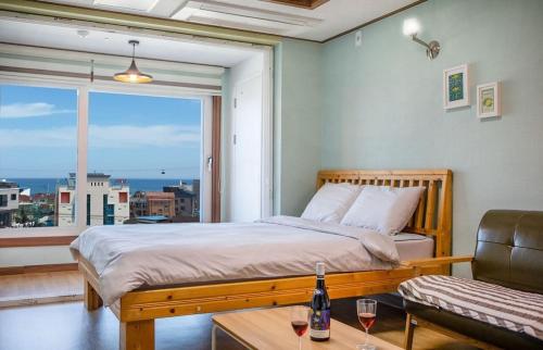 a bedroom with a bed and a large window at Pension Ora in Samcheok