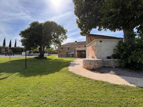 a house with a tree and a grass yard at Casa Rural Mas Homs in Parets de Dalt