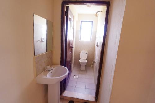 a bathroom with a toilet and a sink at The Nest Apartment Darad in Ukunda Airport